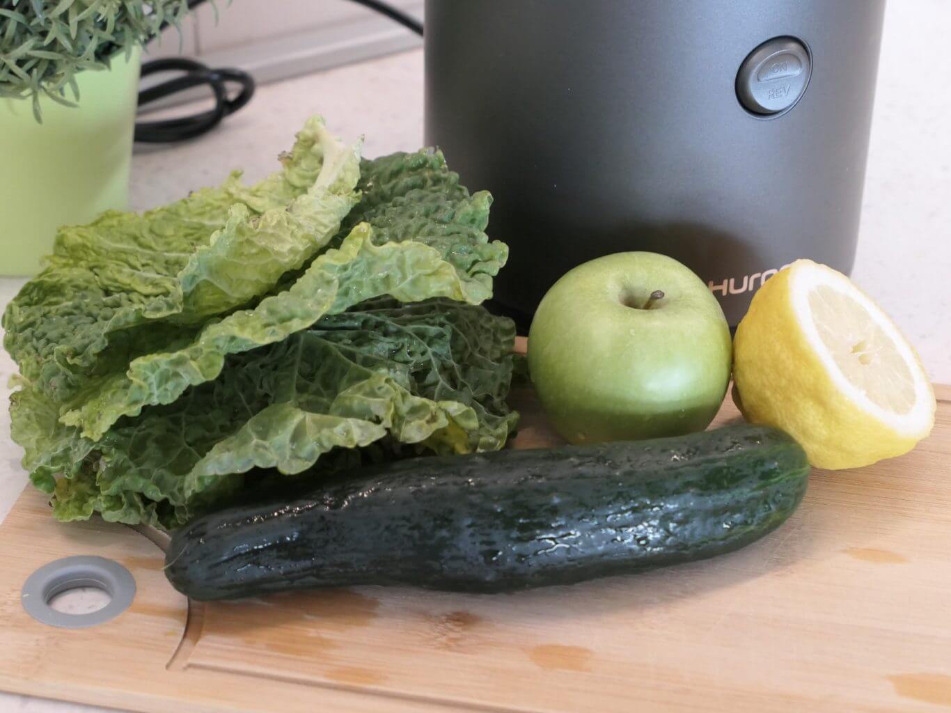 Kale, Cucumber, Lemon and apple in front of Hurom H320N slow juicer which is really similar to the Nama J2
