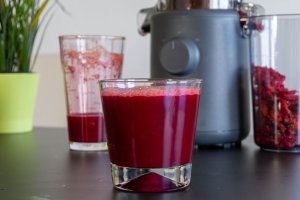 Detox bost juice in a glass in front of Hurom H310A juicer